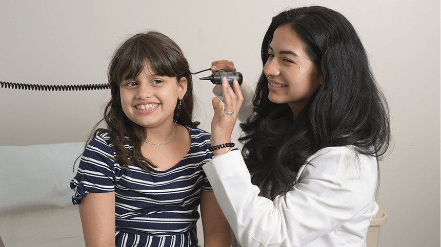 Doctor looking into child patient's ear